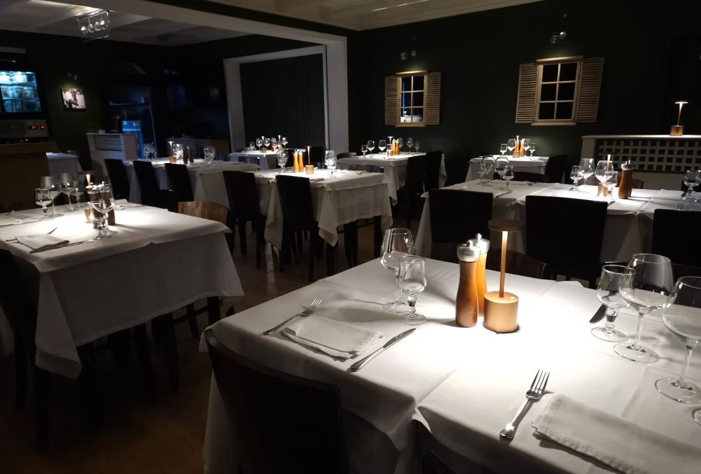 Salle à manger en soirée, bougies allumées sur les tables